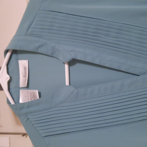 Is green button-down top with buttons on sleevesDown top with buttons on sleeves - Picture 2 of 3